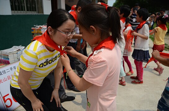 捐贈儀式上，孩子們?yōu)閻坌奶焓瓜瞪霞t領巾