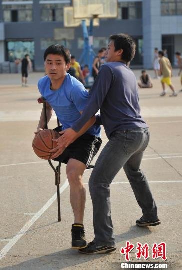 圖為拄著拐杖的瞿詩(shī)濤和同學(xué)搶球。劉占昆攝