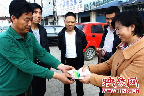 好的哥馬文學(xué)(左一)將現(xiàn)金及銀行卡還給失主 好的哥馬文學(xué)(左一)將現(xiàn)金及銀行卡還給失主