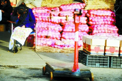 水果批發(fā)市場(chǎng)內(nèi)，沒(méi)有客戶時(shí)，商戶在繡十字繡