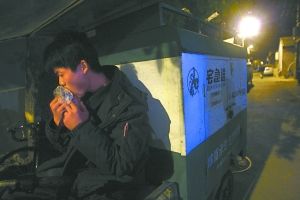 快遞哥抽空吃兩口東西。記者 李剛 攝