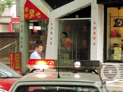 闖入面館的持刀男子與趕來的民警隔著玻璃門對峙，后店內(nèi)一名女童被其劫持。網(wǎng)友供圖