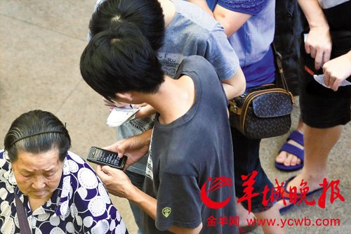 排隊的“黃?！备魇謭?zhí)一疊白紙，上面寫好了要掛號的人的信息，包括姓名、電話、要掛的科室等。穿黑白花紋衣服的老婆婆正在排隊掛號