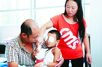 斌斌手術(shù)后第一天恢復(fù)良好，斌斌父母在用玩具逗他開心供圖/嚴(yán)益