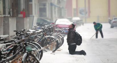 小伙子跪在樓前，一直抬頭看著樓上。 孫立國/攝