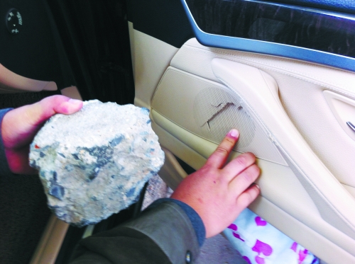 “飛”進寶馬車內(nèi)的大石塊,將寶馬車的車門內(nèi)飾板砸爛。