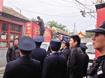 昨日下午,東城區(qū)工商、城管、公安等部門,對雍和宮附近的預(yù)測中心進(jìn)行清理整頓,站在車頂?shù)膬擅と苏鸪患摇邦A(yù)測中心”的招牌。因雍和宮、白云觀等文化景點(diǎn)外聚集大量算命先生,被媒體稱為“算命一條街”。本版攝影/新京報(bào)記者 李寧 攝