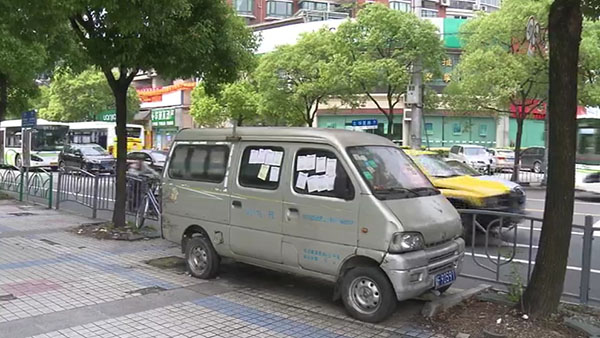 被棄置在人行道上的面包車。