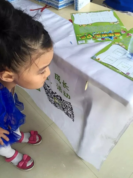 一只蝴蝶飛到小蝸牛的旗子上，小朋友看得入神啦~