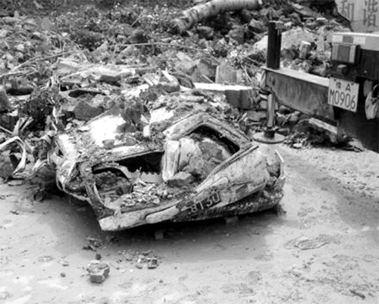 7月2日，新密市區(qū)，暴雨沖倒圍墻，一輛汽車被砸成“鐵餅”