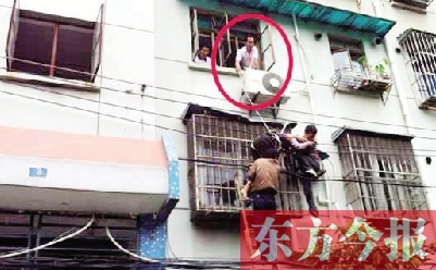 施救現場，劉鵬（圈內）先用繩子捆住老太確保安全 勞動報記者 郭娜 供圖