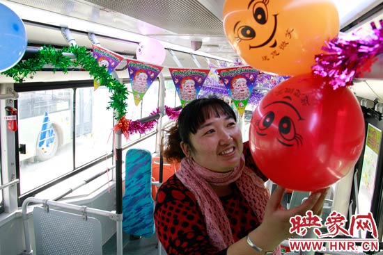 鄭州快速公交B3區(qū)間線車長李鵬云在車廂里懸掛氣球，布置圣誕車廂，營造歡樂圣誕氛圍