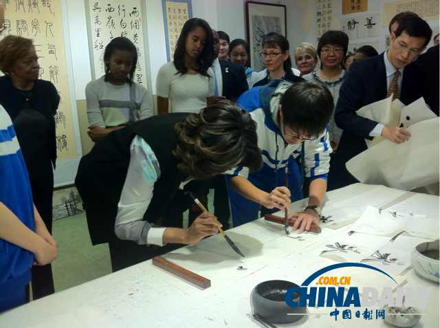 　北京時間3月21日，美國第一夫人米歇爾參觀北師大二附中時，與學生一起練習書法。