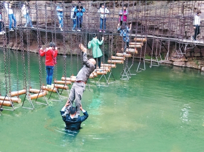 中年男游客正踩著景區(qū)安全員郭小明的肩膀過河。網友“@我的小名叫張孩”供圖