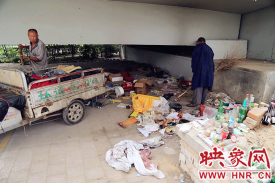 負責(zé)高架橋下綠化的人員在清理流浪漢留下的垃圾和雜物。