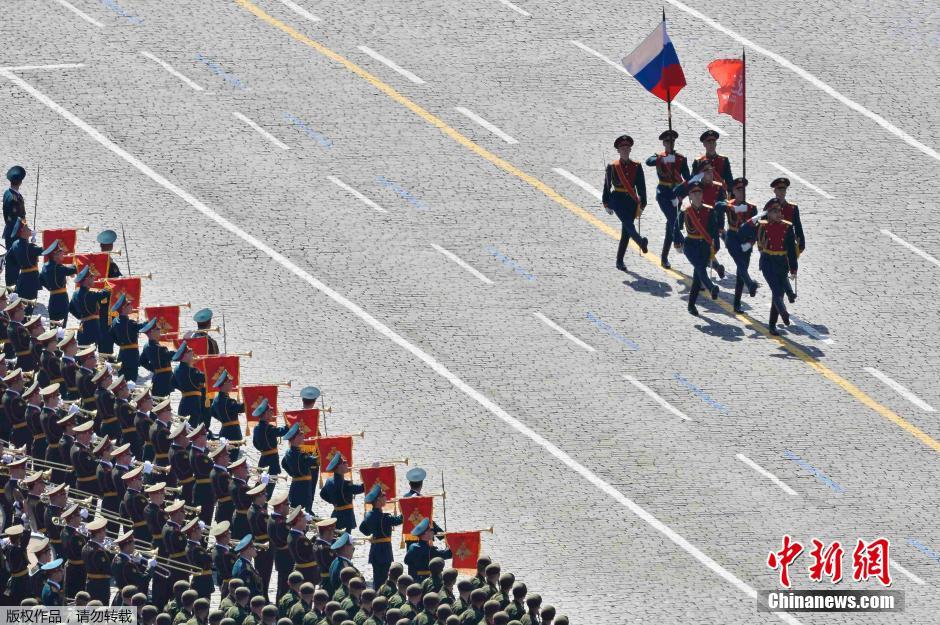 圖為俄羅斯國旗從受閱部隊前經(jīng)過。