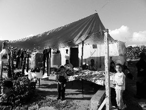 黎巴嫩一敘利亞難民營，難民支起攤鋪賣衣服掙錢。