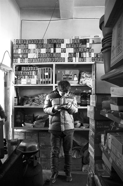 1月21日，周瑋在自家的超市里玩計算器。