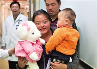 昨日上午，被扎針女嬰的母親抱著孩子和醫(yī)護(hù)人員送的玩偶準(zhǔn)備出院，院方稱孩子術(shù)后恢復(fù)良好。記者 高瑋 攝