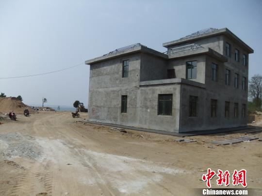 鴨河水庫(kù)庫(kù)區(qū)邊的新建別墅，一面墻上寫著“拆”，另一邊在加緊施工。吳揚(yáng)　攝